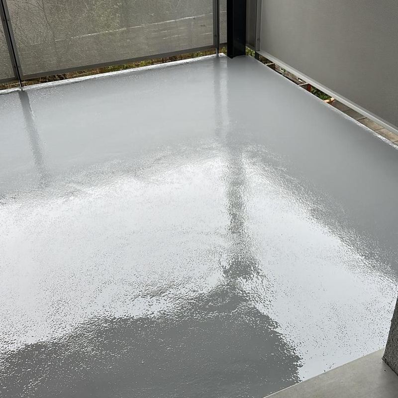 Résine blanche en cours d'application sur un balcon