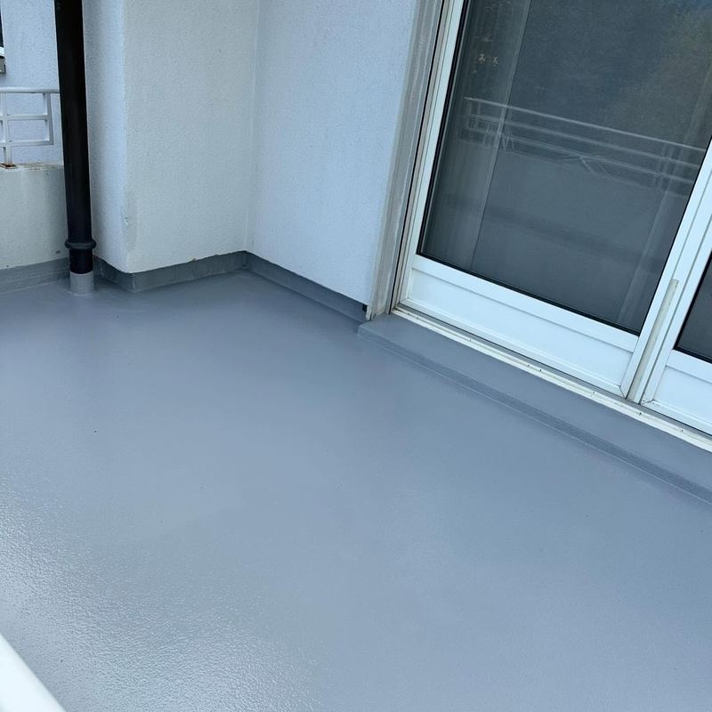 Balcon en résine gris-bleu devant une baie vitrée