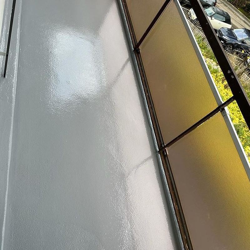 Balcon en résine gris clair derrière un garde-corps vitré