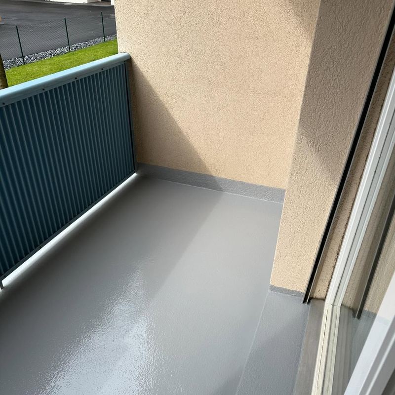 Balcon en résine grise le long d'un store vert
