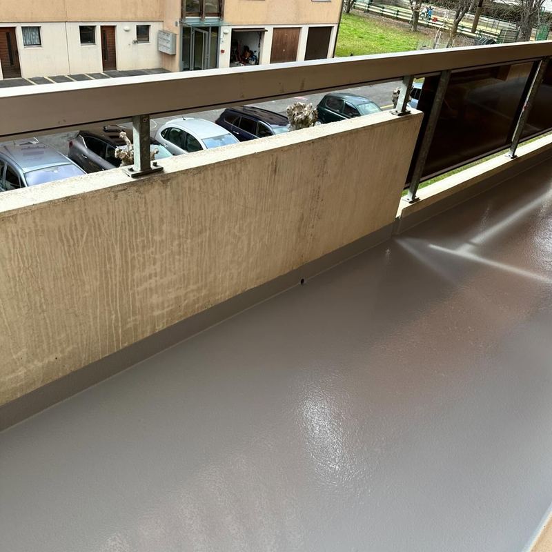 Coursive d'immeuble en résine beige, au-dessus du parking