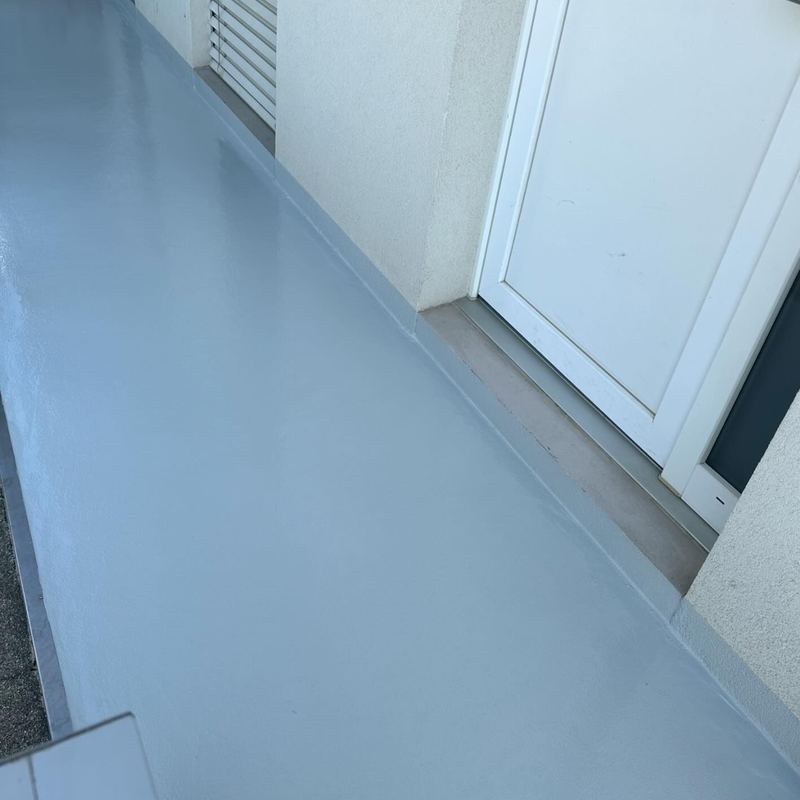 Coursive extérieure en résine bleu clair devant les entrées