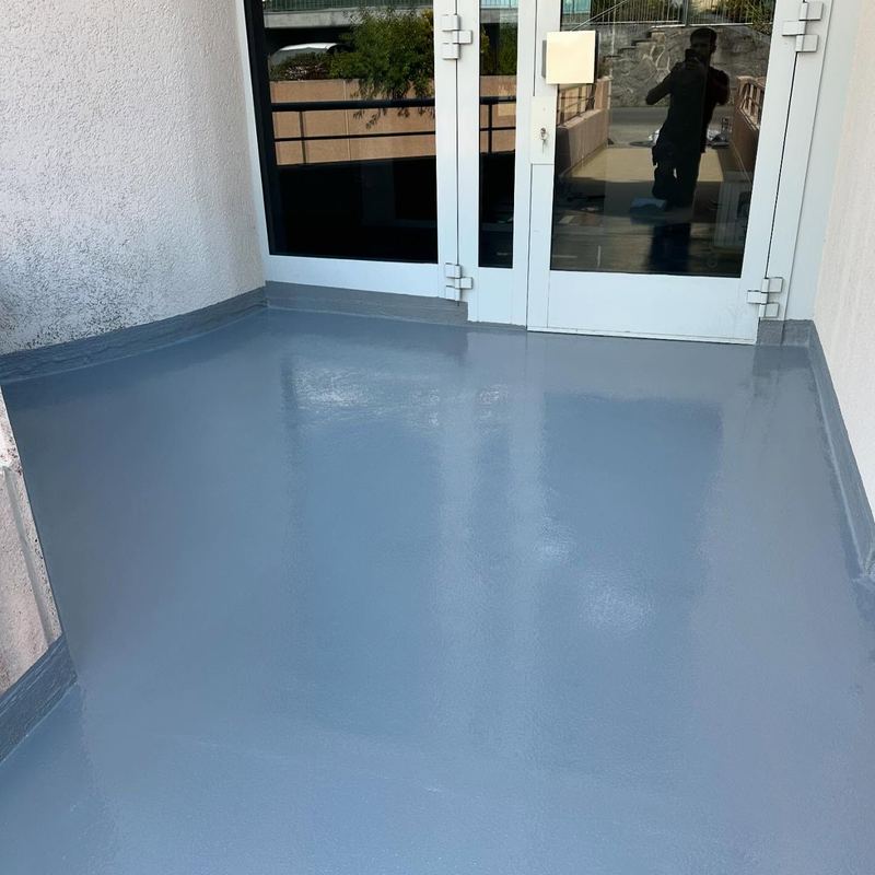 Loggia en résine bleu-gris devant des portes vitrées