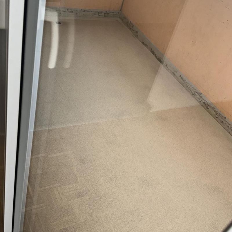 Petit balcon en résine beige devant la baie vitrée