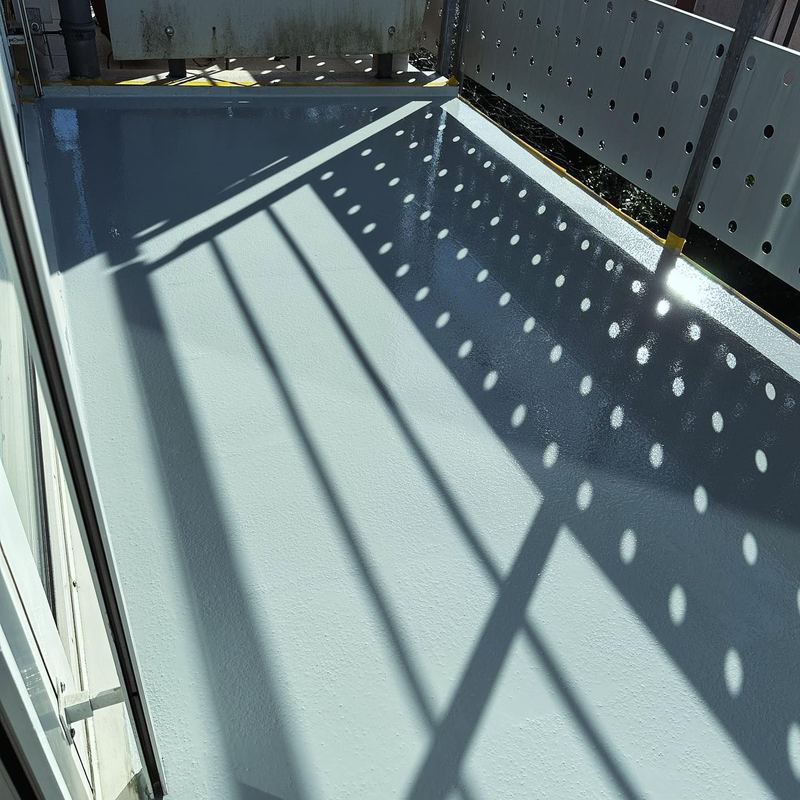 Terrasse en résine gris-bleu sous l'ombre du store