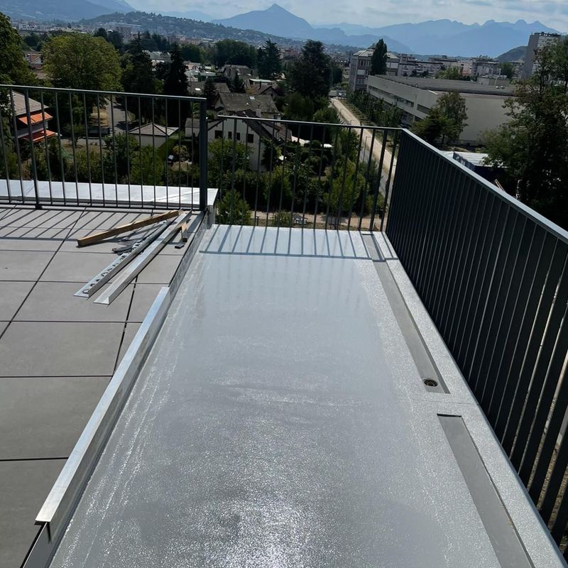 Toit-terrasse en résine grise avec vue sur les montagnes
